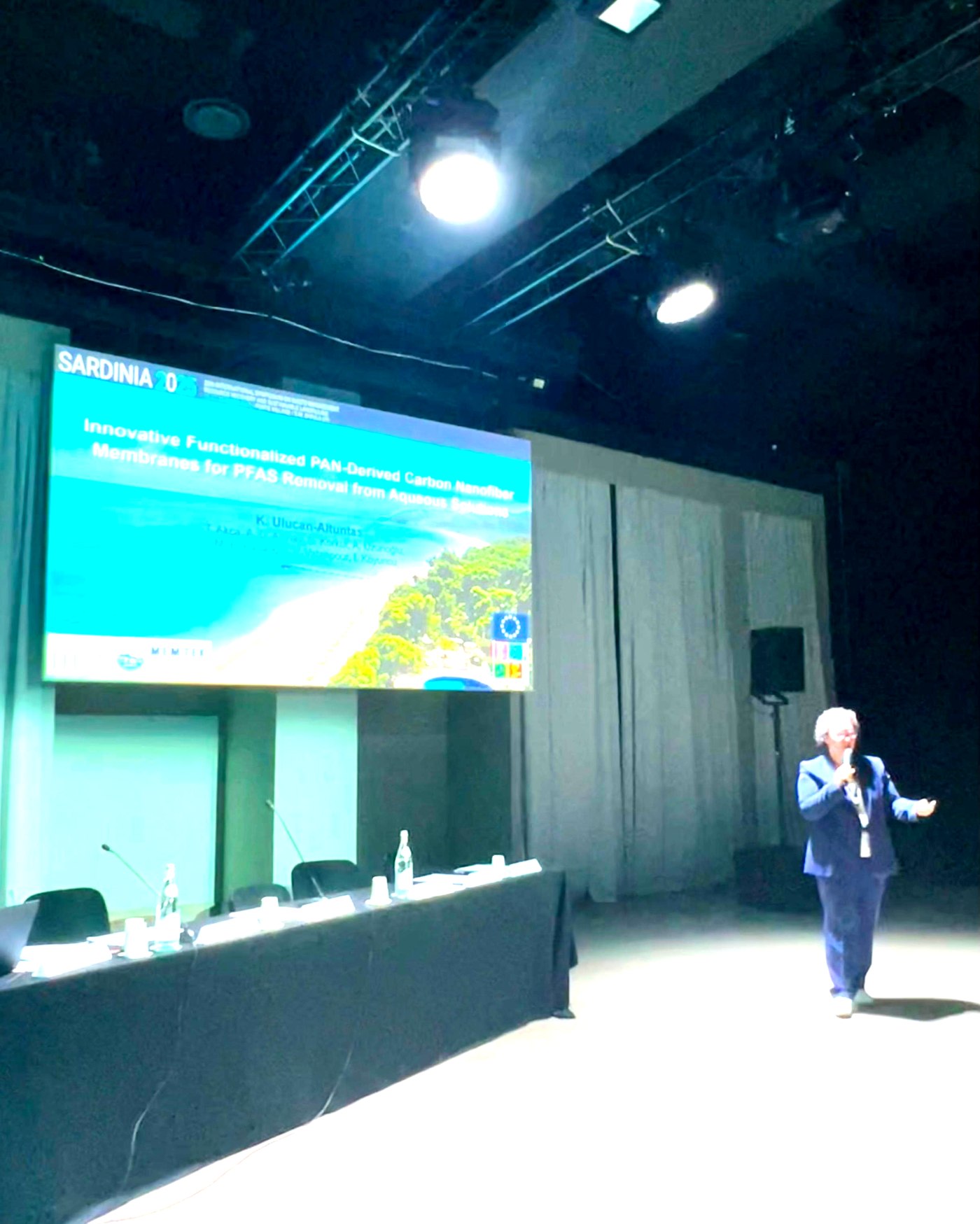 Kubra Ulucan-Altuntas presenting on stage, wide view of the auditorium